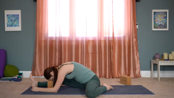 Yoga teacher leaning forward in a yin yoga for hips stretch