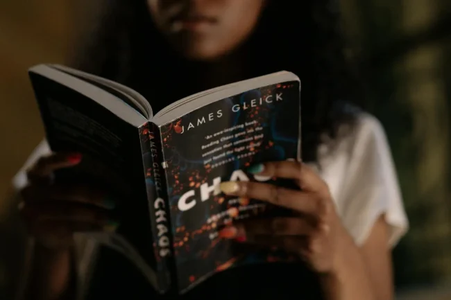 A woman reading a book with the title "Chaos" A woman reading a book with the title "Chaos"