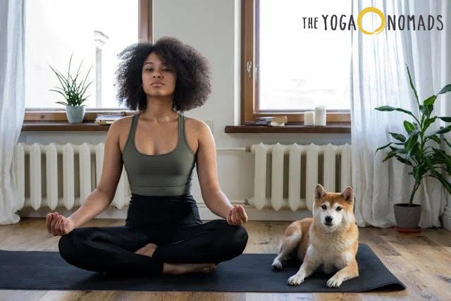 A woman sitting on a yoga mat with her dog 