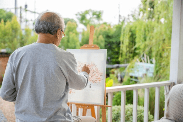 A person painting on a canvas
Description automatically generated