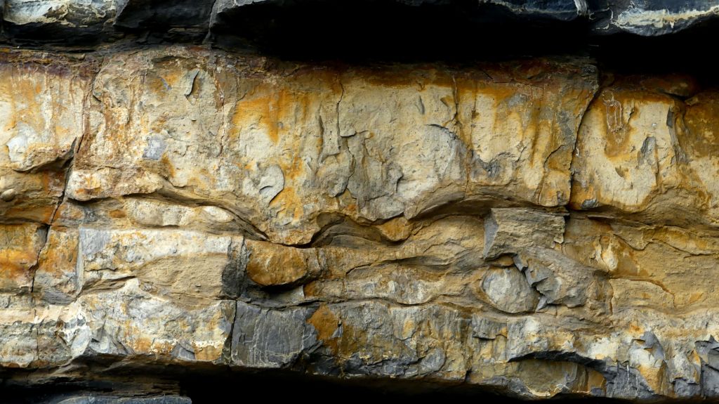 Detail of eroding cliff face showing alternating bands of Jurassic limestone and mudstone at Dunraven Bay on the Glamorgan Heritage Coast.