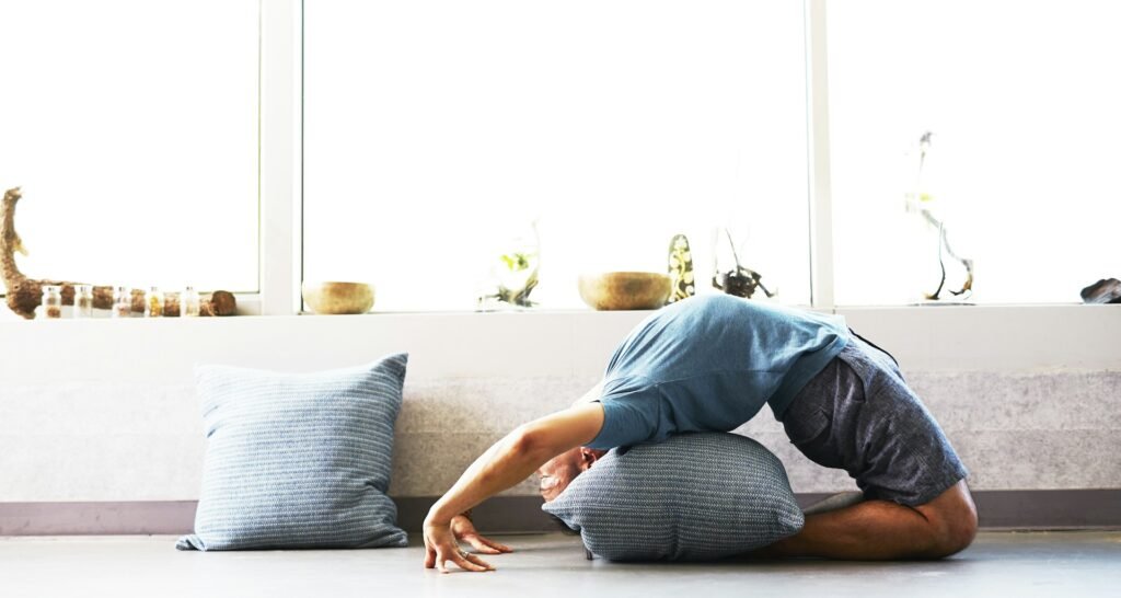Smart Props: Everyday Household Items You Can Use in Place of Yoga Gear Household Items You Can Use in Place of Yoga Gear 3 A man using pillow as support while doing a yoga pose