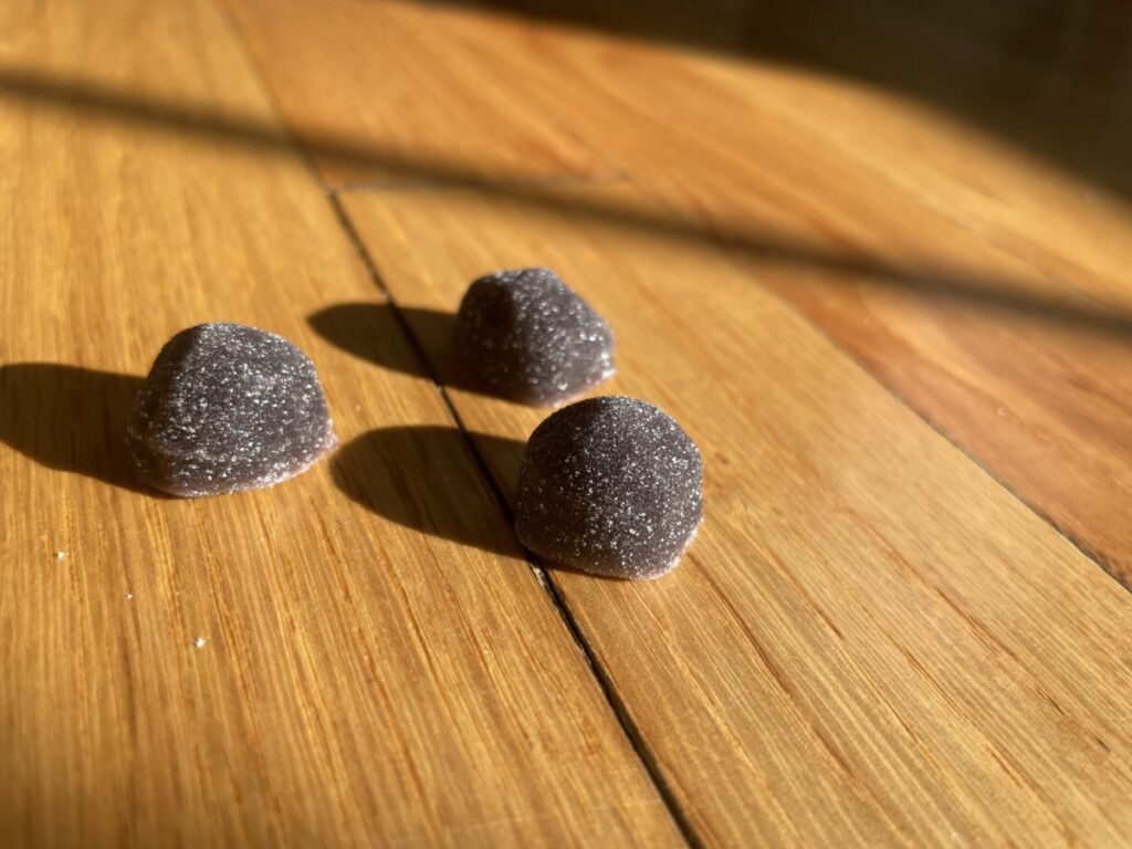 Image of three purple melatonin gummies shown to resemble candy.