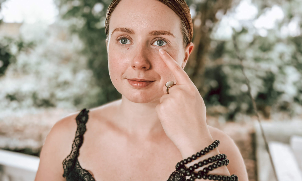 Close-up of EFT face tapping technique under the eye. This tapping point is associated with the stomach meridian and is used to reduce physical stress and emotional pressure.