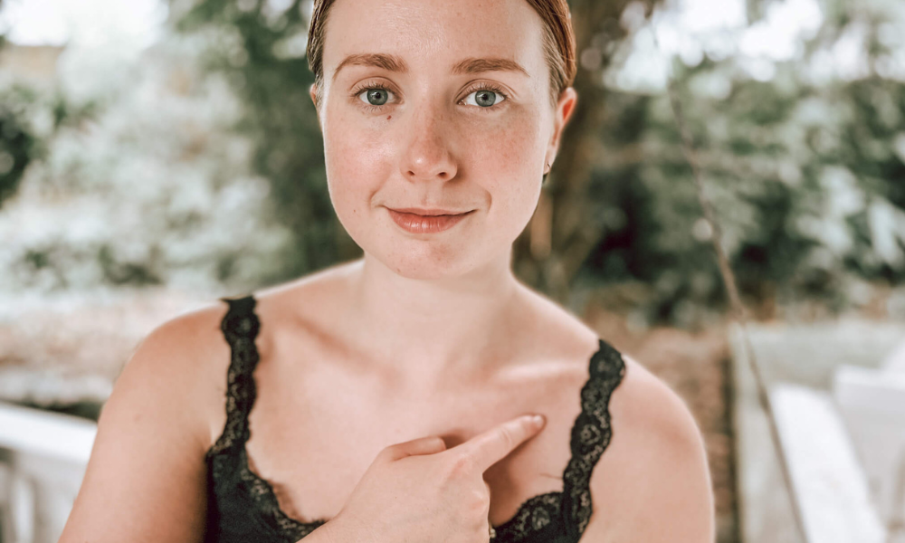 Demonstrating EFT tapping at the collarbone point, which supports calming the nervous system and reducing fear. Connects to the kidney meridian.