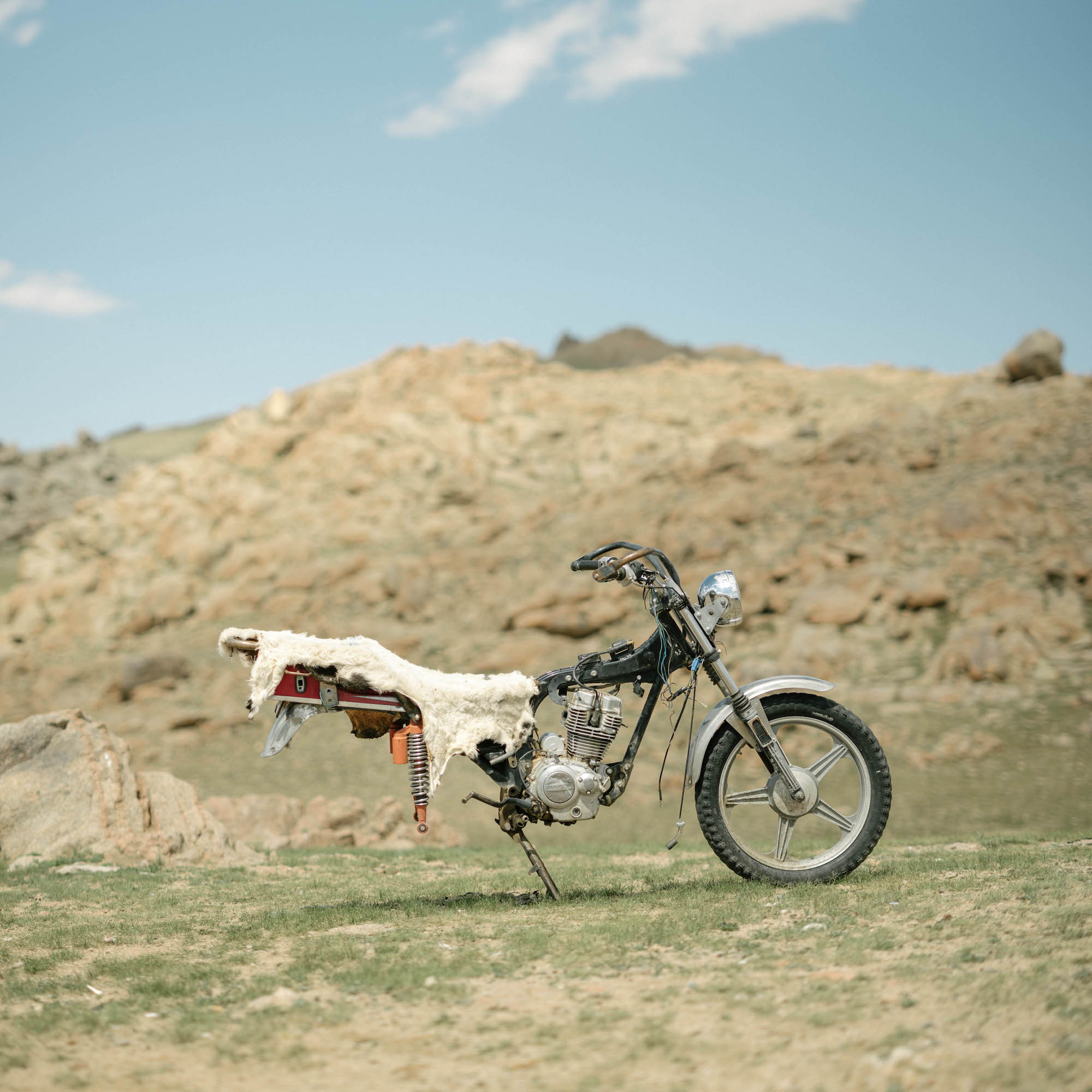 The front end of a motorbike, with the rear tire missing. 